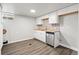 Basement kitchen with butcher block counters, white cabinets, and stainless steel dishwasher at 741 S 6Th Ave, Brighton, CO 80601
