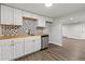Basement kitchen features a stainless steel dishwasher, light cabinets, and unique backsplash at 741 S 6Th Ave, Brighton, CO 80601