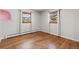 Charming bedroom with hardwood floors and natural light from two windows with white curtains at 741 S 6Th Ave, Brighton, CO 80601