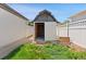 Exterior view of a white storage shed in a fenced backyard, with grass and landscaping at 741 S 6Th Ave, Brighton, CO 80601