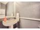 Cozy bathroom with a white pedestal sink, framed mirror, and textured walls at 22150 E Berry Pl, Aurora, CO 80015