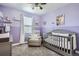 Charming Bedroom with a gray crib and soft lavender walls and carpet flooring at 22150 E Berry Pl, Aurora, CO 80015