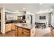 Open kitchen featuring an island, wood cabinets, black countertops, and an adjacent dining area at 22150 E Berry Pl, Aurora, CO 80015