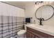 Stylish bathroom featuring modern fixtures, a gray and white shower curtain, and a round mirror at 8334 Pebble Creek Way # 201, Highlands Ranch, CO 80126