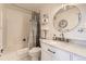 Cozy bathroom with a shower-tub combo, decorative shelves, and a modern round mirror at 8334 Pebble Creek Way # 201, Highlands Ranch, CO 80126