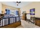 Comfortable bedroom featuring a wooden bed frame, ceiling fan, and a Colorado Rockies poster at 8334 Pebble Creek Way # 201, Highlands Ranch, CO 80126