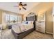Spacious bedroom with a tufted headboard bed, large windows, and neutral decor at 8334 Pebble Creek Way # 201, Highlands Ranch, CO 80126