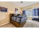 Bedroom with a wooden platform bed, built-in shelves, and bright blue curtains at 8334 Pebble Creek Way # 201, Highlands Ranch, CO 80126