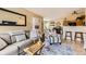 Open-concept living area featuring a leather sofa, striped chair, and view into the dining area at 8334 Pebble Creek Way # 201, Highlands Ranch, CO 80126