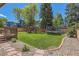 Fenced backyard with lawn, trampoline, swing set, and landscaping at 728 Poppywood Pl, Highlands Ranch, CO 80126