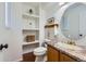 Cozy half-bathroom showcasing built-in shelves, decorative fixtures, and warm neutral tones at 728 Poppywood Pl, Highlands Ranch, CO 80126