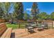 Wooden deck features outdoor furniture and a view of a fenced backyard with playground at 728 Poppywood Pl, Highlands Ranch, CO 80126