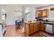 Open kitchen with hardwood floors and stainless steel dishwasher leading to dining area at 728 Poppywood Pl, Highlands Ranch, CO 80126