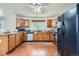 Well-lit kitchen with wooden cabinets, stainless steel dishwasher and appliances, plus hardwood floors at 728 Poppywood Pl, Highlands Ranch, CO 80126