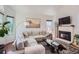 Comfortable living room with a cozy fireplace, plush sofa, and large windows at 728 Poppywood Pl, Highlands Ranch, CO 80126
