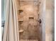 Beautiful tiled shower equipped with built-in shelving and a shower curtain at 728 Poppywood Pl, Highlands Ranch, CO 80126