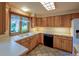Bright kitchen featuring wood cabinets, a black dishwasher, and a large window above the sink at 790 Mohawk Dr, Boulder, CO 80303