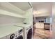 Convenient laundry area with a modern washer and dryer, complemented by shelving and a view to the kitchen at 836 S Vance St # D, Lakewood, CO 80226