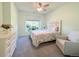 Light-filled bedroom with neutral tones, carpet, a ceiling fan, and a decorative headboard at 4760 S Wadsworth Blvd # F105, Littleton, CO 80123