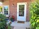 Charming front porch featuring brick facade, a white door, and decorative plants at 4760 S Wadsworth Blvd # F105, Littleton, CO 80123