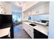 Modern kitchen with white cabinets, stainless steel appliances, and open view of the living area at 4760 S Wadsworth Blvd # F105, Littleton, CO 80123