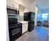 Updated kitchen with white cabinets, black appliances, and contemporary backsplash at 4760 S Wadsworth Blvd # F105, Littleton, CO 80123
