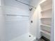 All-white shower with built-in niche and a tiled backsplash, next to built in shelving at 4760 S Wadsworth Blvd # F105, Littleton, CO 80123