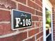 Unit F-105 at Mirabelago is marked with a sign on a red brick wall at 4760 S Wadsworth Blvd # F105, Littleton, CO 80123