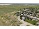 A picturesque aerial view of a quiet neighborhood with a mix of homes, green lawns, and natural landscapes at 6123 Dunraven Rd, Golden, CO 80403