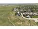 An aerial shot showcasing a beautiful home in a neighborhood surrounded by green spaces and winding roads at 6123 Dunraven Rd, Golden, CO 80403