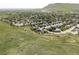 Expansive aerial view of a serene residential community nestled against a lush green landscape and majestic mountains at 6123 Dunraven Rd, Golden, CO 80403
