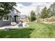 Backyard showcasing a patio with outdoor furniture, a well-maintained lawn, and retaining wall landscaping at 6123 Dunraven Rd, Golden, CO 80403