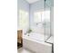 Modern bathroom featuring a soaking tub, tile surround, and two windows allowing natural light at 6123 Dunraven Rd, Golden, CO 80403