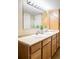 Bathroom featuring a double vanity, matching cabinets, and a large mirror with lighting at 6123 Dunraven Rd, Golden, CO 80403