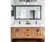 Bathroom featuring wood vanity with double sinks, a large mirror and modern light fixtures at 6123 Dunraven Rd, Golden, CO 80403