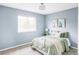 Relaxing bedroom featuring a large window, light blue walls, and a cozy queen bed at 6123 Dunraven Rd, Golden, CO 80403