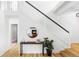 Entryway with a staircase featuring white railing, hardwood floors, and round mirror over console table at 6123 Dunraven Rd, Golden, CO 80403