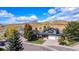 Exterior view of home with manicured lawn and three car garage at 6123 Dunraven Rd, Golden, CO 80403