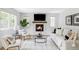 Bright living room featuring a fireplace, hardwood floors, modern furniture, and large windows at 6123 Dunraven Rd, Golden, CO 80403