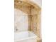 Elegant tub and shower with tiled walls, neutral accents, and overhead lighting at 6123 Dunraven Rd, Golden, CO 80403