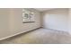 Bright bedroom features neutral carpet and large window with view of mature trees at 18043 E Ohio Ave # 202, Aurora, CO 80017