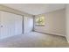 Comfortable bedroom with neutral carpet, large closet, and a view of mature trees at 18043 E Ohio Ave # 202, Aurora, CO 80017