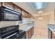 Efficient kitchen with wood cabinets and modern appliances offers easy access to dining area at 18043 E Ohio Ave # 202, Aurora, CO 80017