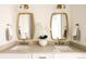 A well-lit dual sink bathroom with modern mirrors, lighting, and white cabinetry at 2751 Curtis St, Denver, CO 80205