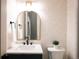 Stylish powder room with patterned wallpaper, and an arched mirror at 2751 Curtis St, Denver, CO 80205