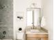 Bright bathroom features gray tiled shower, neutral vanity with sink, and framed mirror at 2751 Curtis St, Denver, CO 80205