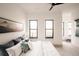 Sun-filled bedroom with plush pillows, black frame windows, and views into the home's other rooms at 2751 Curtis St, Denver, CO 80205