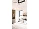 Brightly lit bedroom shows access to the on-suite bathroom, fan, mountainscape decor, and neutral bedding at 2751 Curtis St, Denver, CO 80205