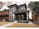 Modern two-story brick home featuring a covered porch, second-story balcony, and manicured lawn at 2751 Curtis St, Denver, CO 80205