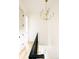 Hallway with modern chandelier, dark railing and trim and white walls at 2751 Curtis St, Denver, CO 80205